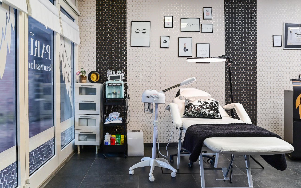 De behandelkamer van de beautysalon met behandelstoel, apparatuur en wenkbrauwprints aan de wand